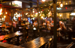Busy Australian restaurant dining area at night with warm lighting, wooden tables and guests seated throughout the venue.